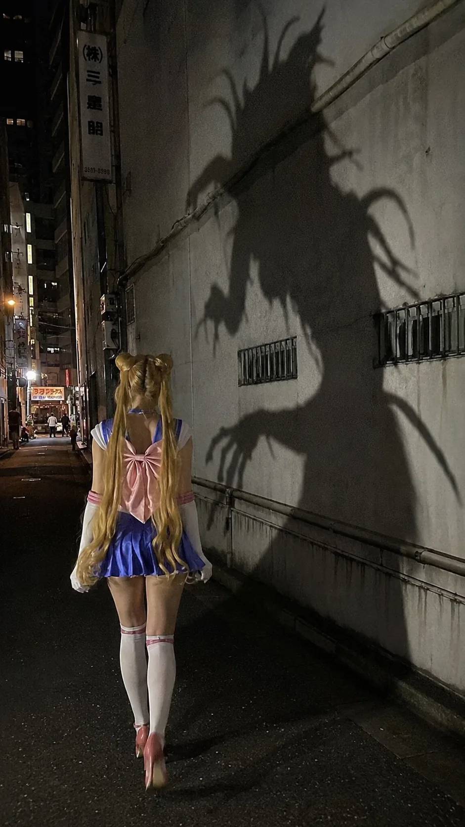 攔截版：穿水手服的少女走在小巷，牆上投出怪物影子